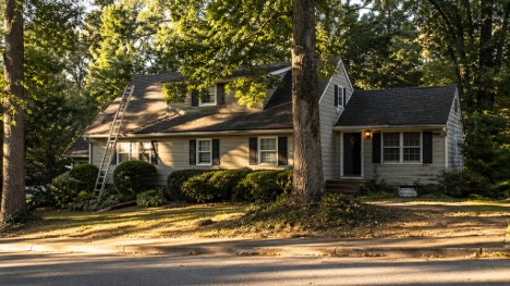 Older home in Buford GA with mature trees and visible signs of routine maintenance in a quiet neighborhood